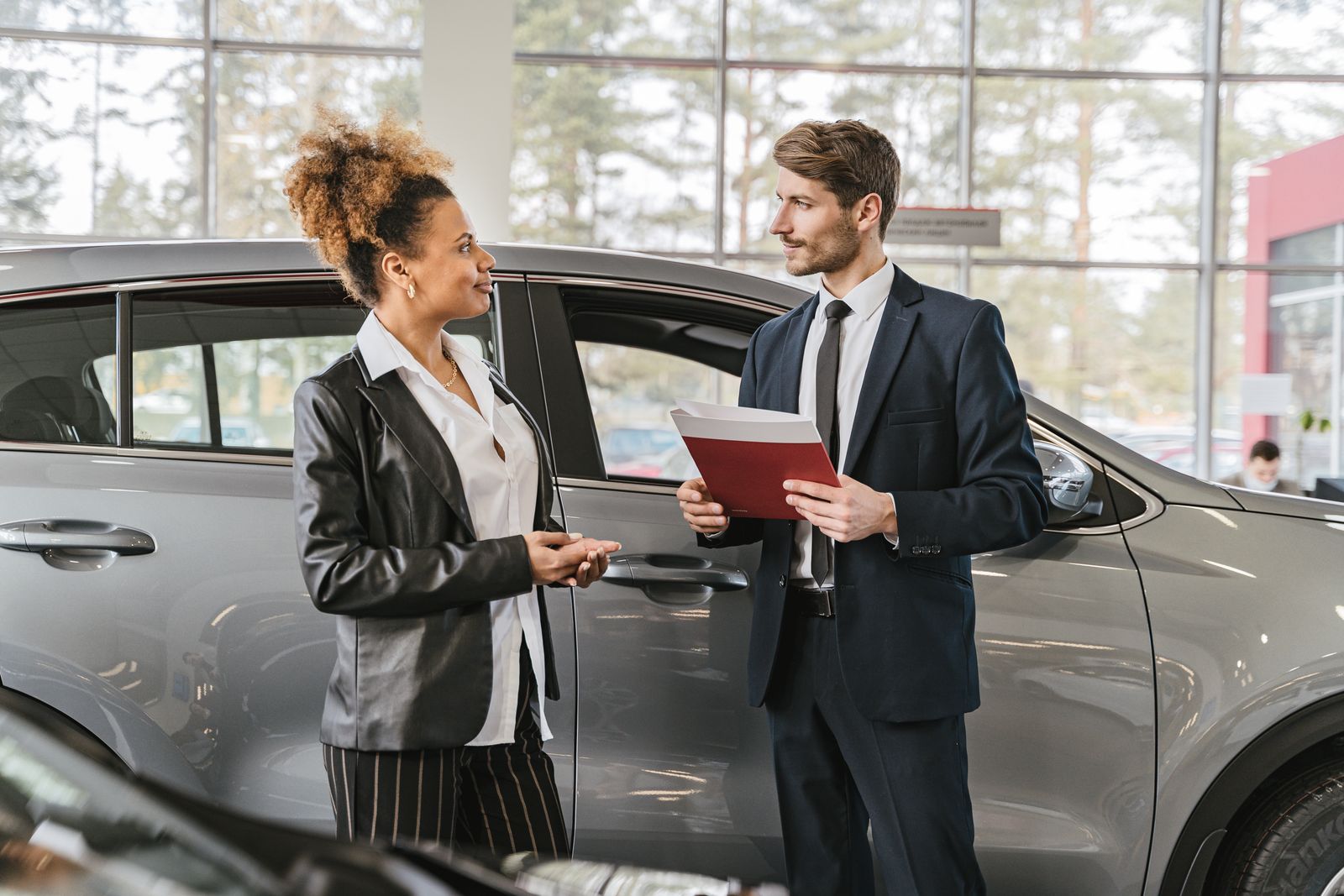 A conversation on a car dealership showroom floor
